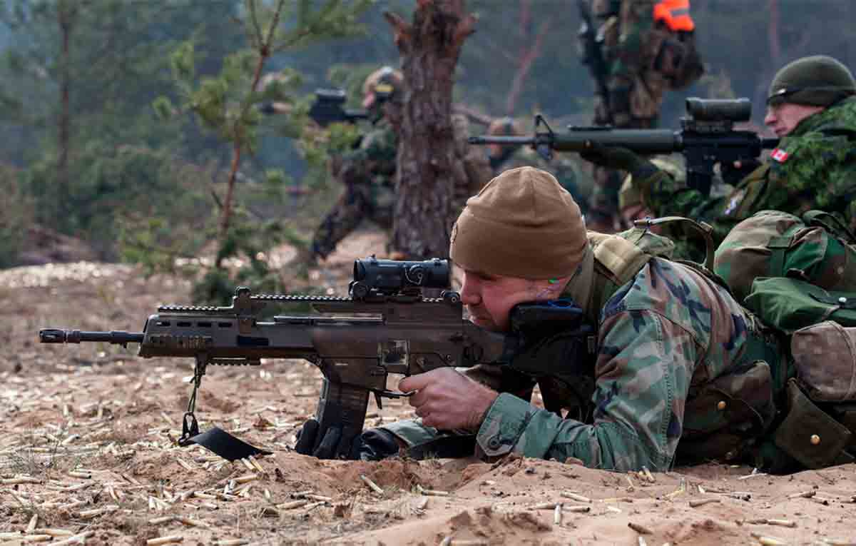 Um soldado do exército letão mira com seu rifle de assalto Heckler & Koch G36.